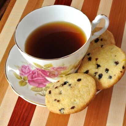 lemon currant cornmeal cookies on saucer with teacup