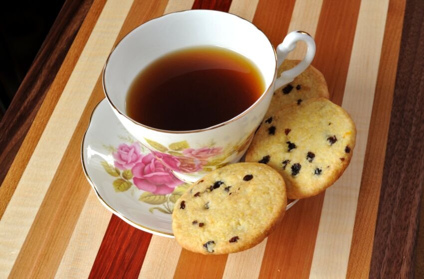 lemon currant cornmeal cookies on saucer with teacup